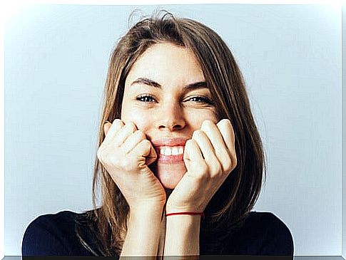 woman-smiling-with-hands-on-face