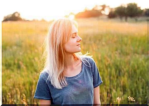 woman with eyes closed in the field.