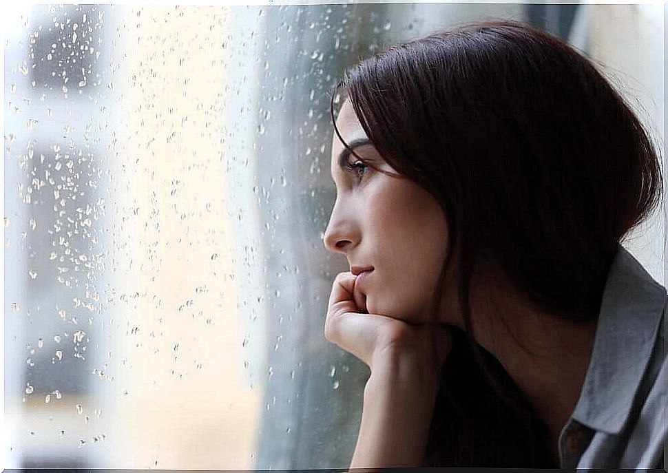 woman watching rain at the window