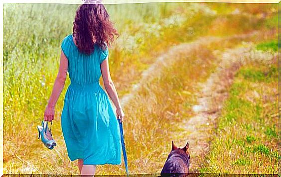 woman walking through the field with her dog