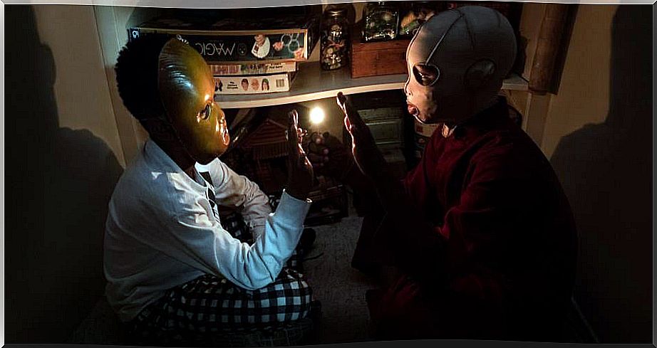 Two children with masks in the dark